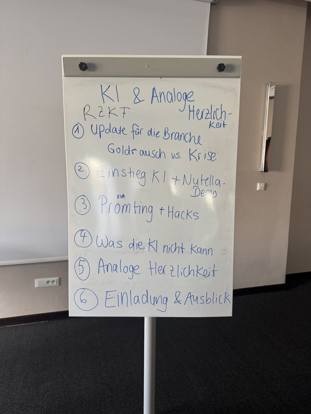 Flipchart mit der handgeschriebenen Überschrift KI und analoge Herzlichkeit